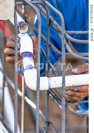 Plumber Installing PVC Pipe at Construction Site Plumber Installing PVC Pipe at Construction Site 47879099
