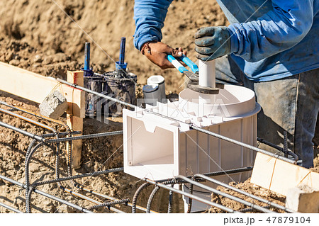 Plumber Uses Wrench to Install Pipe at Worksite 47879104