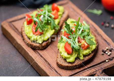 Healthy toast with avocado, tomato, arugula Healthy toast with avocado, tomato, arugula 47879198