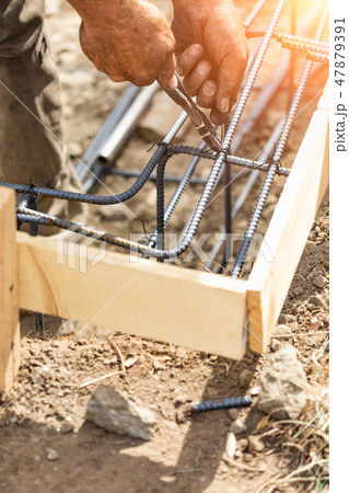 Worker Secures Steel Rebar Framing With Plier Tool Worker Secures Steel Rebar Framing With Plier Tool 47879391