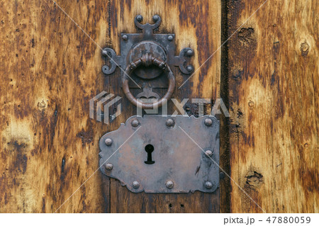 Old medieval keyhole and door knob on ancient wooden texture, closeup. Old medieval keyhole and door knob on ancient wooden texture, closeup. 47880059