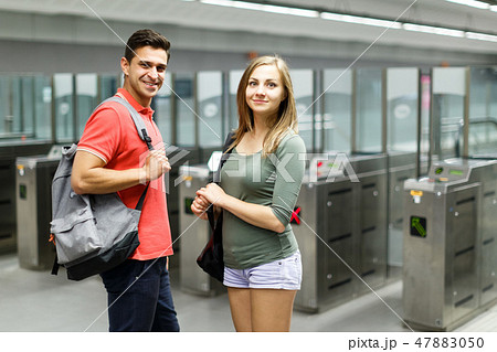 Couple is standing near turnstiles and moving around the city 47883050