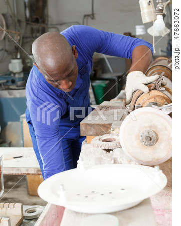 Worker engaged in adjustment of equipment 47883072