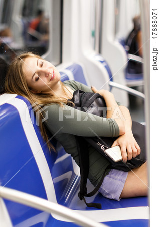 Female is traveling and sitting with mobile in the train 47883074