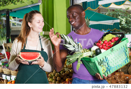 Seller standing with male client with basket Seller standing with male client with basket 47883132