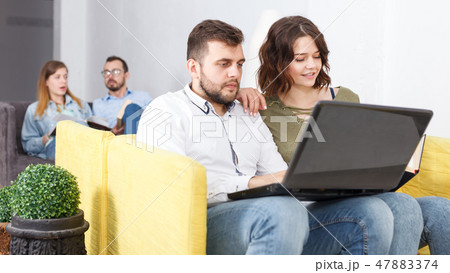 Woman and man with laptop and book Woman and man with laptop and book 47883374