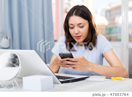 Young girl student using laptop and phone at the home 47883764