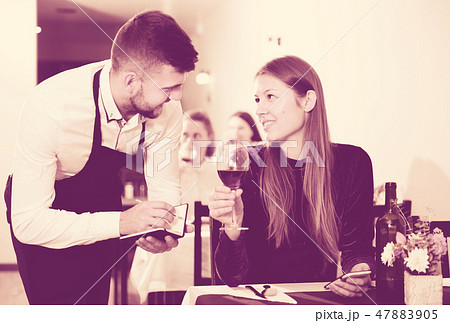 Waiter is taking order from young female in restaurante 47883905
