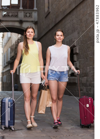 female tourists exploring old european city with baggage female tourists exploring old european city with baggage 47883962