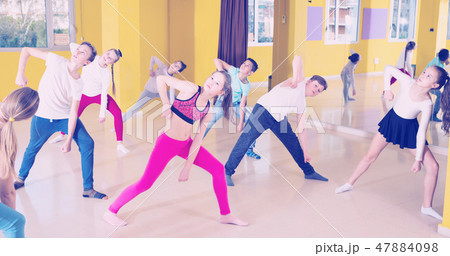 Tweens exercising with coach in choreography class 47884098