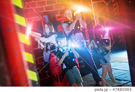 Kids and adults in beams on lasertag arena Kids and adults in beams on lasertag arena 47885003