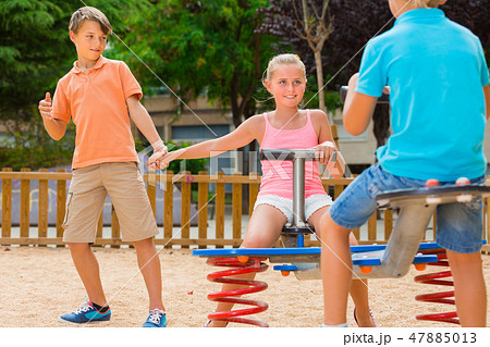 Cheerful children are teetering on the swing Cheerful children are teetering on the swing 47885013