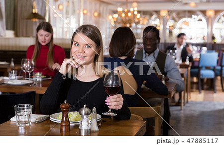 Woman enjoying dinner alone in restaurant 47885117