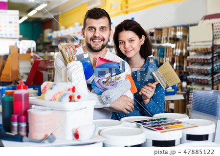 Couple purchasing tools for house improvements in paint supplies store Couple purchasing tools for house improvements in paint supplies store 47885122