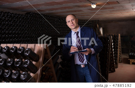Winemaker with clipboard in winery vault Winemaker with clipboard in winery vault 47885192