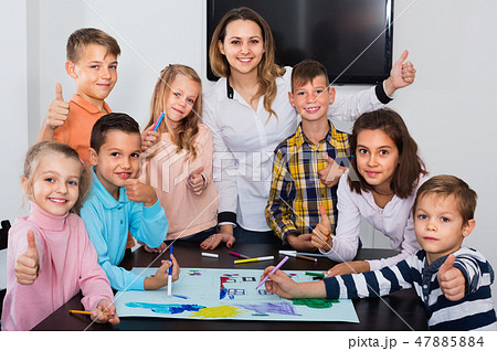 Children with teacher drawing together in classroom 47885884