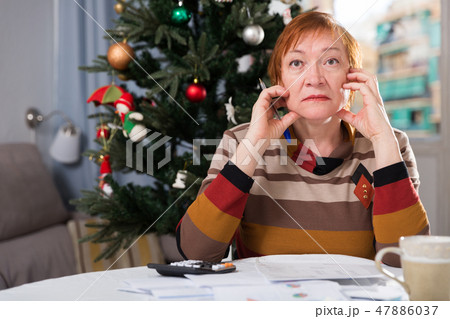 Mature woman calculates utility costs in the new year Mature woman calculates utility costs in the new year 47886037