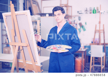 Man near easel painting on canvas 47886658