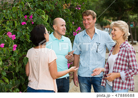 glad pensioners talking in the park 47886688