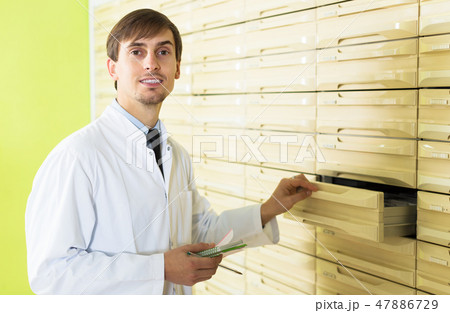 Pharmacist posing in pharmacy depot Pharmacist posing in pharmacy depot 47886729