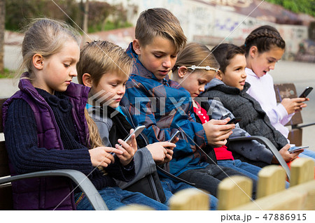 children with mobile devices children with mobile devices 47886915