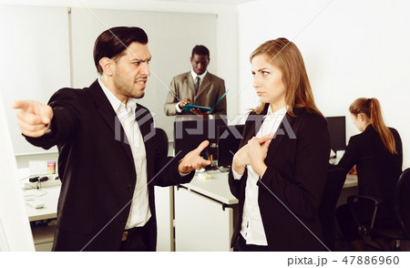 Male boss pointinting to misses in work to woman manager Male boss pointinting to misses in work to woman manager 47886960