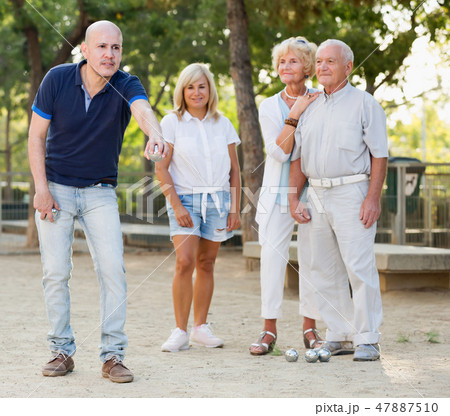 Positive mature people playing petanque Positive mature people playing petanque 47887510