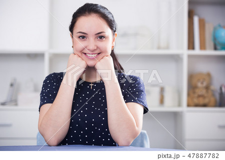 Young girl sitting at table Young girl sitting at table 47887782