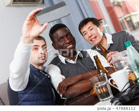 Three friends are taking selfie by phone together Three friends are taking selfie by phone together 47888112