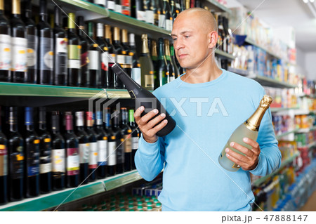 Portrait of young customer selecting wine Portrait of young customer selecting wine 47888147