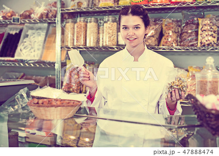 Girl in uniform selling candied fruits and nuts Girl in uniform selling candied fruits and nuts 47888474