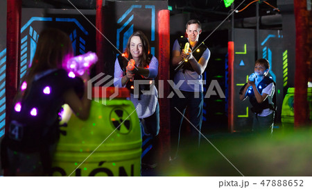 Kids with parents during lasertag game Kids with parents during lasertag game 47888652