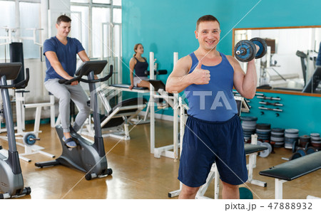 Sporty guy doing exercises with dumbbells Sporty guy doing exercises with dumbbells 47888932