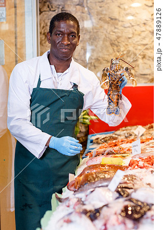 Salesman proposing fresh lobster 47889126