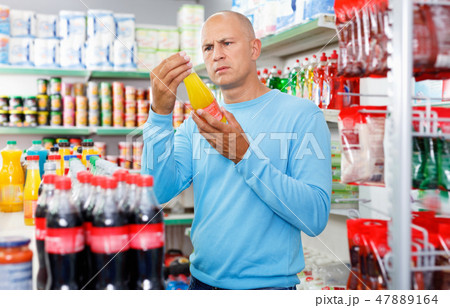 Focused man choosing fresh products during shopping at food store 47889164