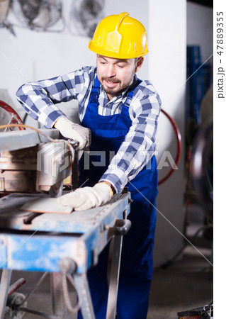 Male is using disk saw to cut tile 47889355