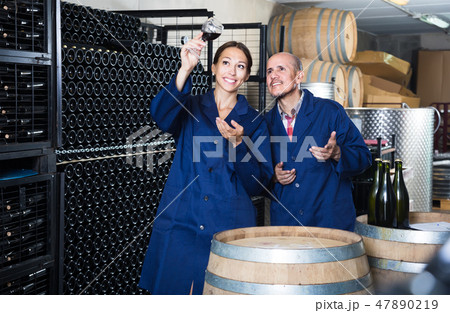 Two positive winery workers in aging section of factory 47890219