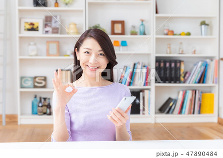 部屋でスマホを見る女性 部屋でスマホを見る女性 47890484