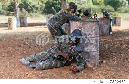 Paintball players of opposite teams in shootout 47890485