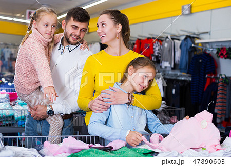 family with two girls choosing new clothes 47890603