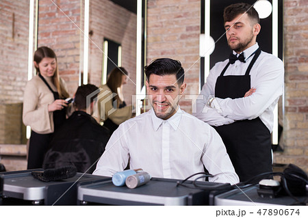 Satisfied man approving result of hairdresser work 47890674