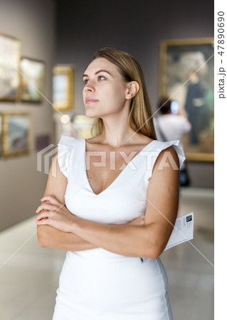 Woman visiting painting exhibition Woman visiting painting exhibition 47890690