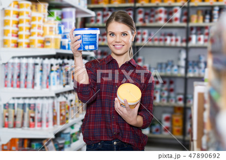 Woman is choosing with paint for repair Woman is choosing with paint for repair 47890692