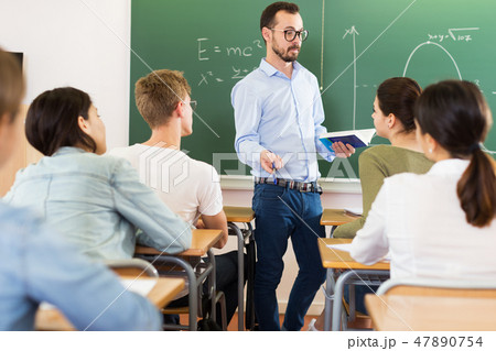 Man teacher giving lecture in classroom Man teacher giving lecture in classroom 47890754