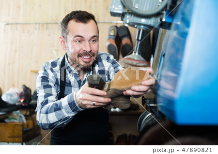 Male worker repairing shoe 47890821