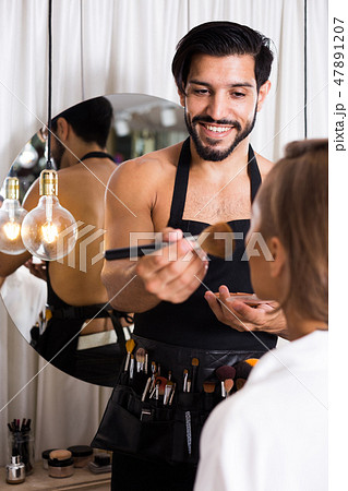 Cheerful male makeup artist applying cosmetics Cheerful male makeup artist applying cosmetics 47891207