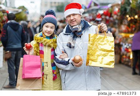 Smiling girl and father with shopping bags Smiling girl and father with shopping bags 47891373