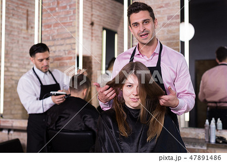Man hairdresser discussing hairstyling with female client 47891486
