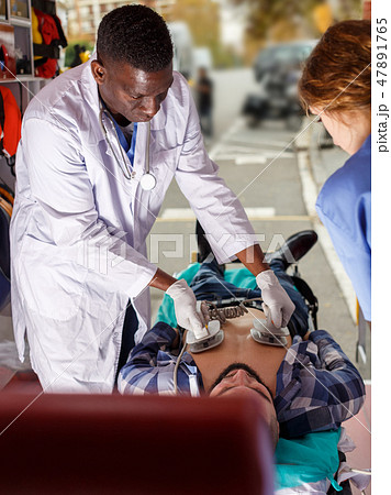 Rescue team making defibrillation to patient 47891765