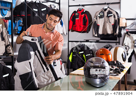 Active man is choosing new jacket for motorbike Active man is choosing new jacket for motorbike 47891904